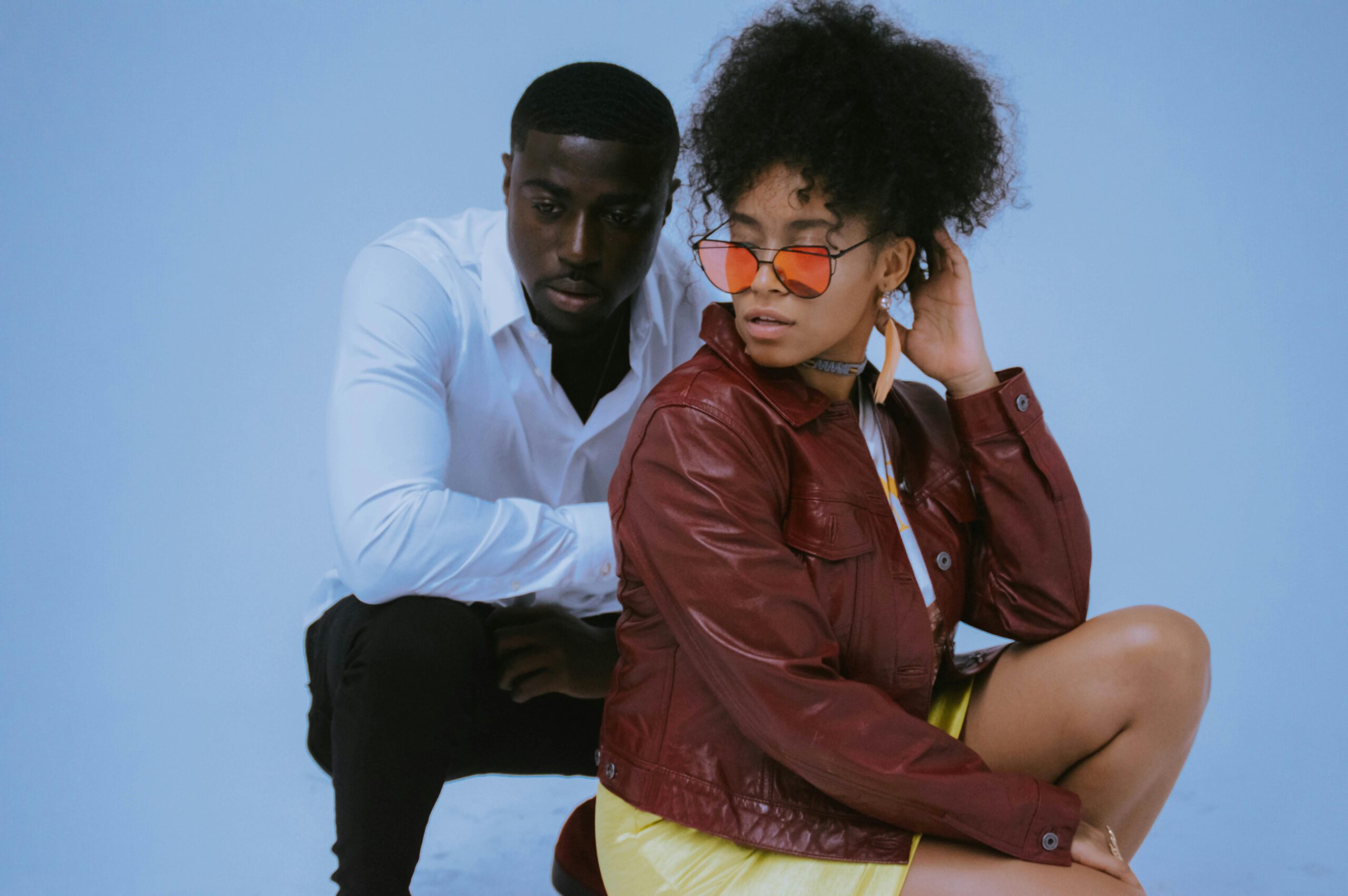 A stylish couple posing in a studio, showcasing modern fashion trends.